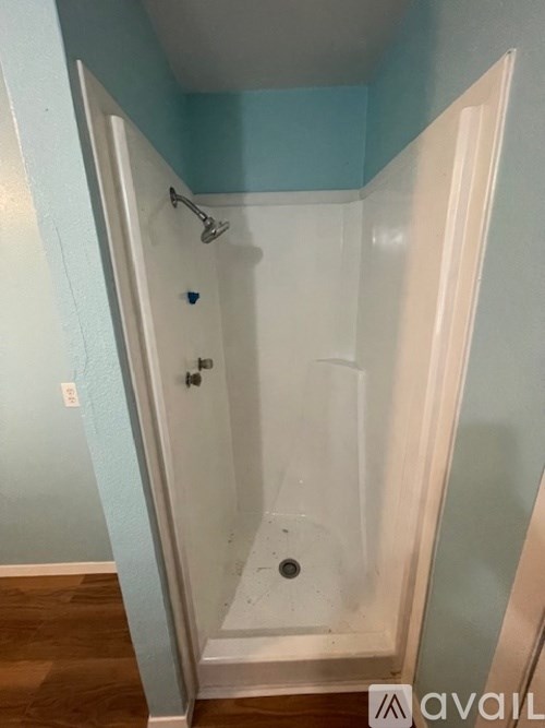 A shower stall with a door open.