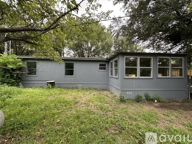 A grey house with a green lawn in front.