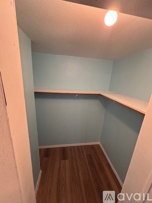 A small room with wooden floors and a light on.