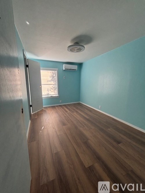 A room with wooden flooring and a ceiling light.
