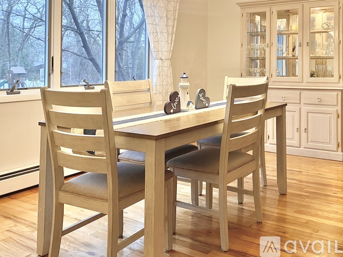 A wooden dining table with two chairs and a tablecloth.