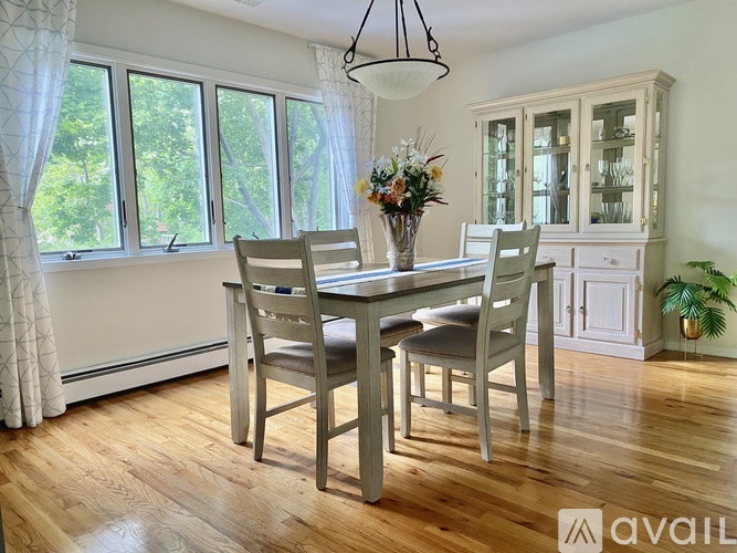 A dining room with a wooden table and chairs.