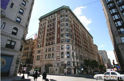 A street view of a city with a white car in the foreground.