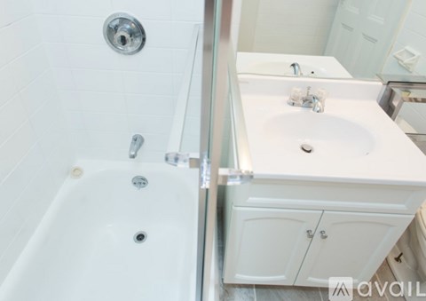 A white bathroom with a tub and sink.