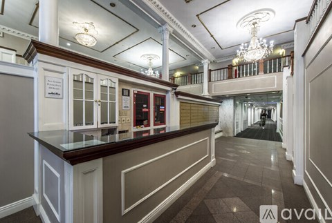 A long hallway with a bar and a chandelier.