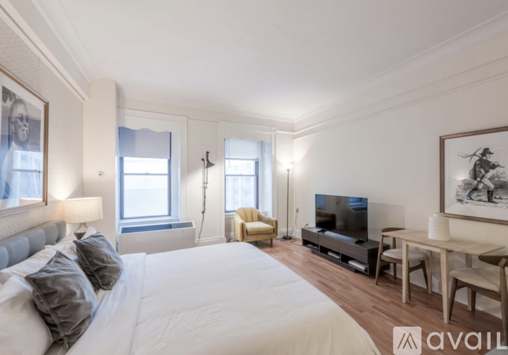 A bedroom with a large bed, a television, and a desk with a chair.