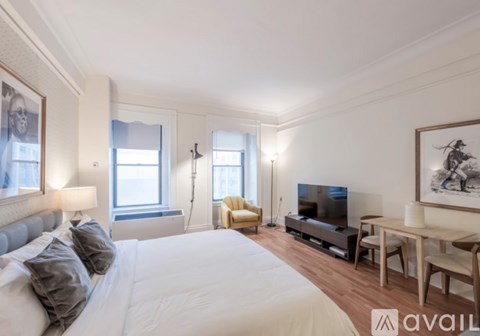 A bedroom with a large bed, a television, and a desk with a chair.