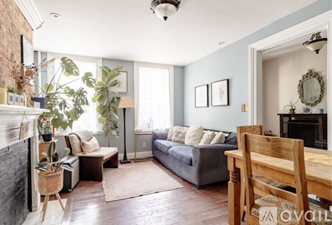 A living room with a grey couch and a wooden chair.