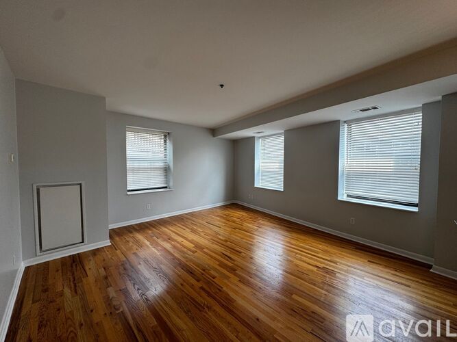 A room with wooden floors and two windows.