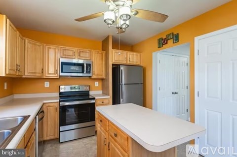 A kitchen with wooden cabinets and a white countertop.