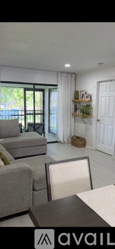 A living room with a grey couch and a white chair.