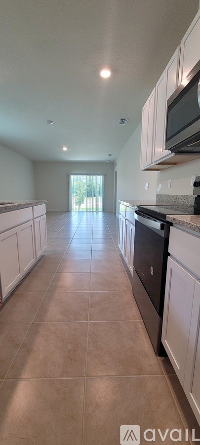 A kitchen with white cabinets and a black dishwasher.