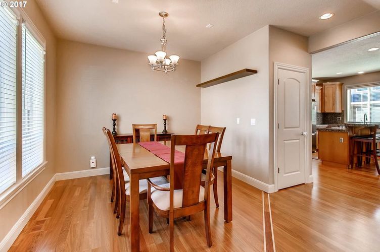 A dining room with a wooden table and chairs.