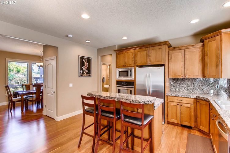 A kitchen with wooden cabinets and a granite countertop.