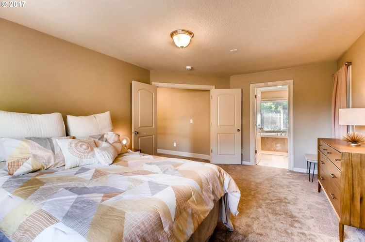 A bedroom with a large bed and a window.