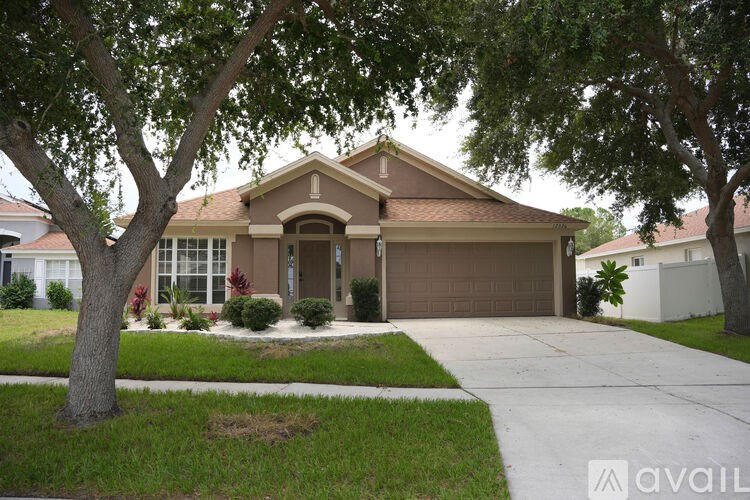 A house with a brown roof and a tree in front.