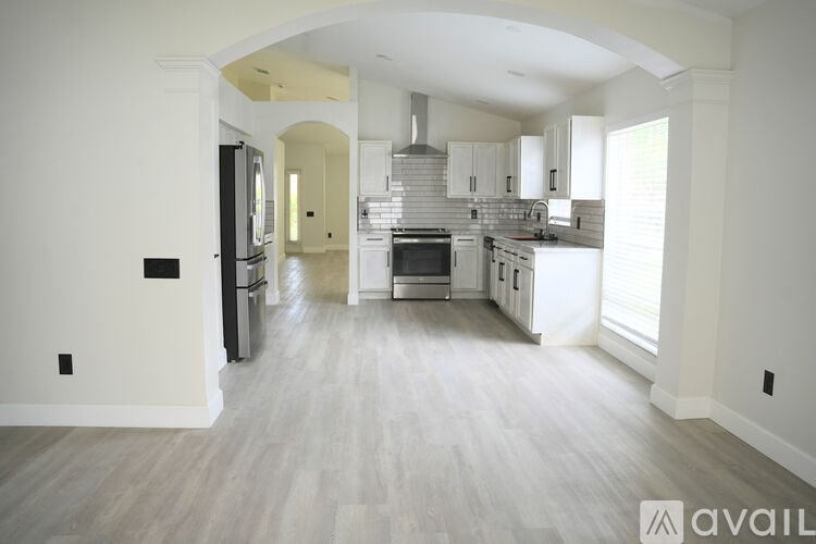 A spacious kitchen with a refrigerator, oven, and cabinets.