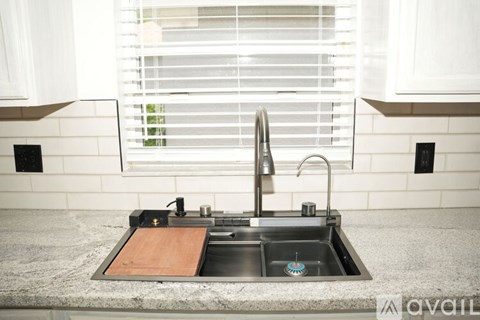 A kitchen sink with a wooden placemat on the counter.