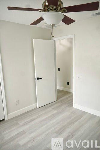 A room with a ceiling fan and a door.