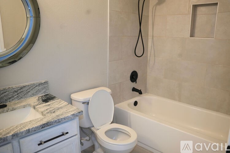 A bathroom with a toilet, sink, and bathtub.