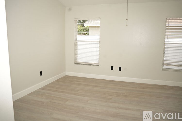 A room with a window and a wooden floor.