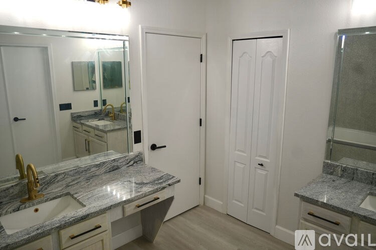 A bathroom with a marble countertop and white doors.