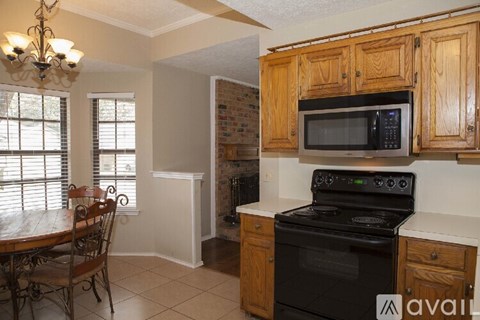 A kitchen with wooden cabinets and a black stove top oven.