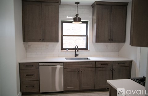 A kitchen with brown cabinets and a white sink.