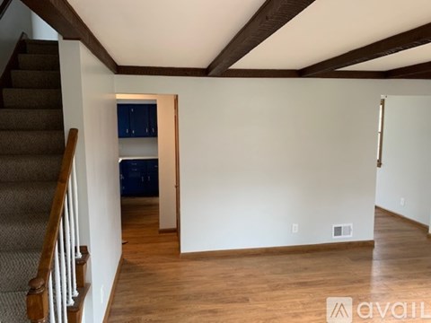 A room with wooden floors and a staircase leading to the upper floor.