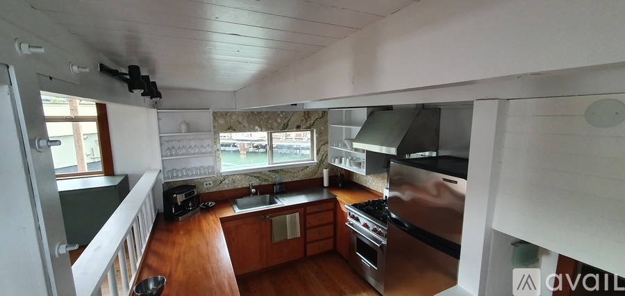 A kitchen with wooden floors and stainless steel appliances.
