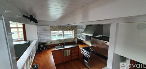 A kitchen with wooden floors and stainless steel appliances.
