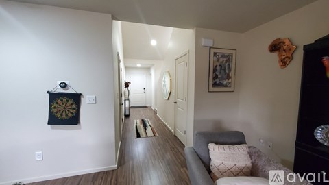 A living room with a grey couch and a wooden floor.