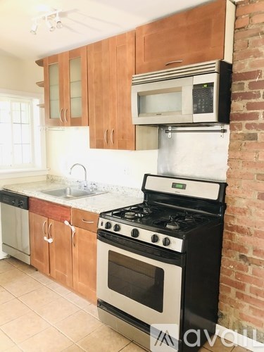 A kitchen with a black stove top oven and a white microwave above it.