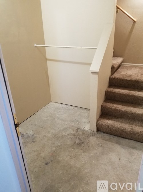 A staircase with a carpeted runner and a white handrail.