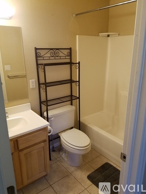 A bathroom with a toilet, sink, and a bunk bed.