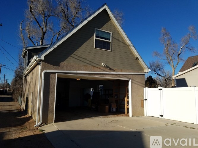 A two-car garage with a brown roof and white fence.