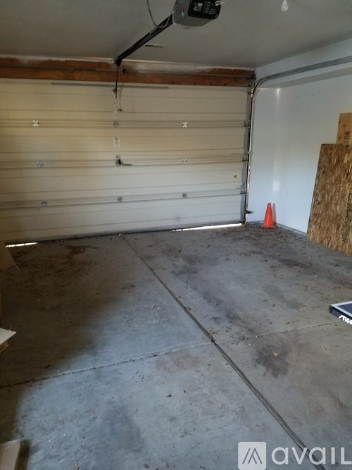 A garage with a closed white door and a concrete floor.