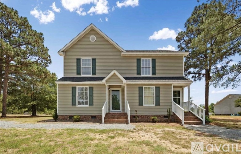 A two-story house with a front porch and green shutters.