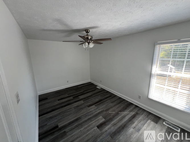 A spacious room with a staircase and a window.