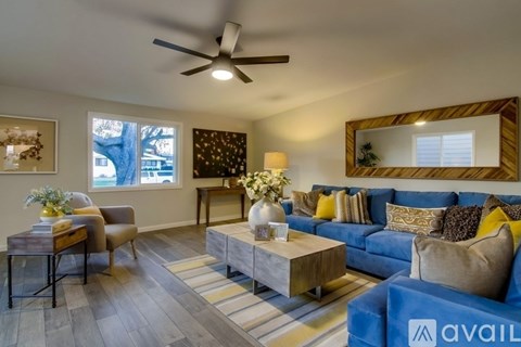 A living room with a blue couch and a wooden coffee table.