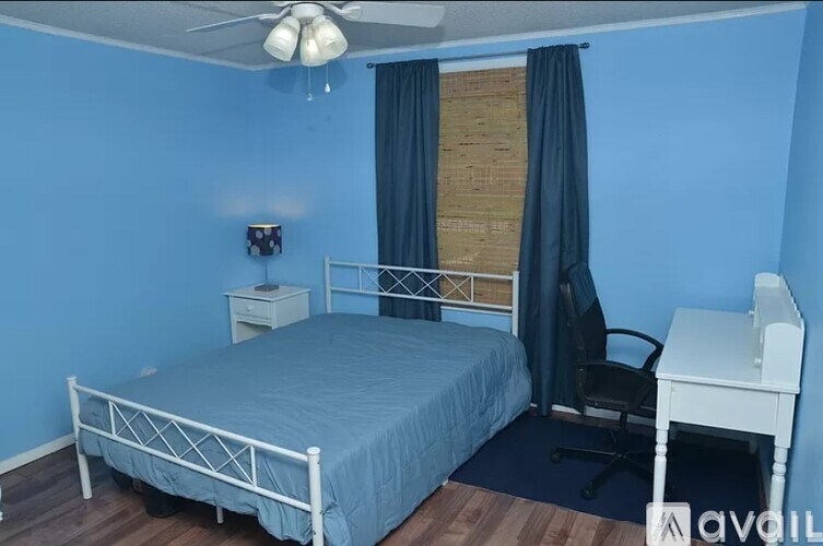 A bathroom with a toilet, sink, and chair.