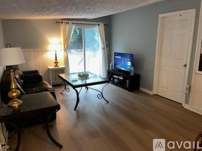 A living room with a television, a sofa, and a coffee table.