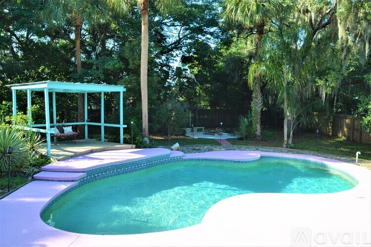 A pool with a white fence and a blue gazebo.