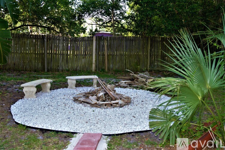 A backyard with a fire pit and a fence.