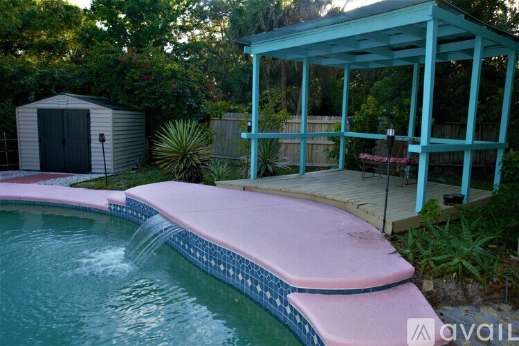 A pool with a pink edge and a blue pool cover.