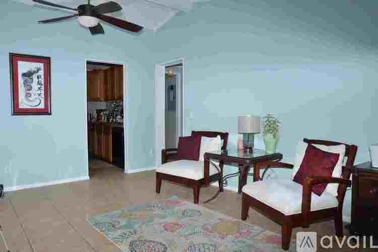 A living room with two chairs and a rug.