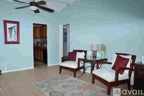 A living room with two chairs and a rug.