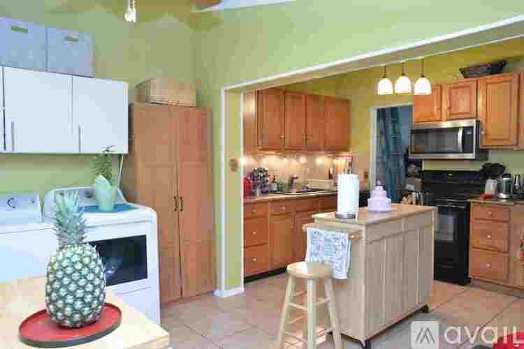A kitchen with a pineapple on the counter.