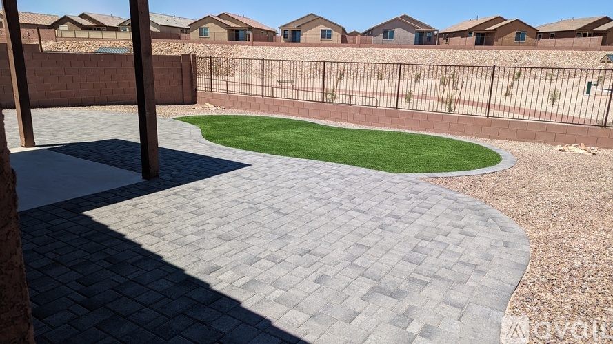 A backyard with a brick patio and a grassy area.