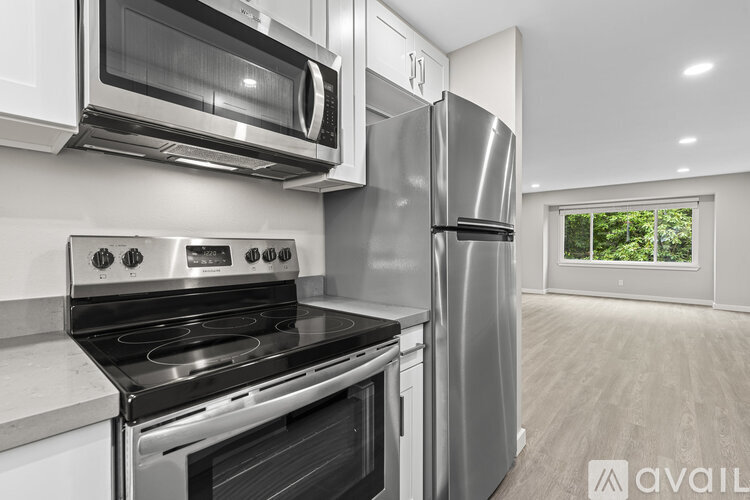 A modern kitchen with stainless steel appliances and a window.